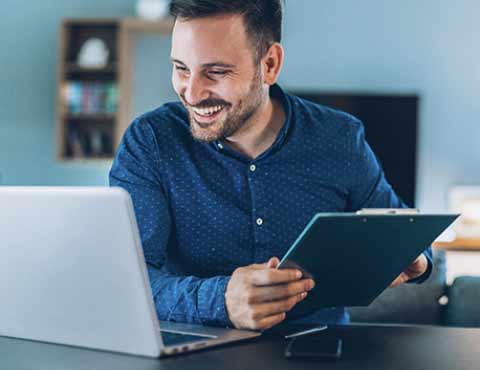 Person smiling while working on a laptop.